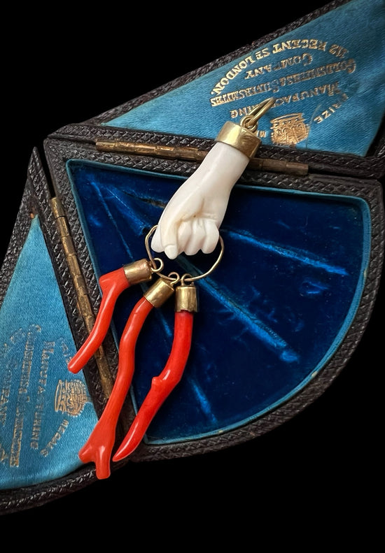 19TH CENTURY CORAL HAND WITH AMULETS