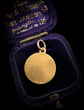 18CT GOLD DISC PENDANT WITH ENAMEL URN